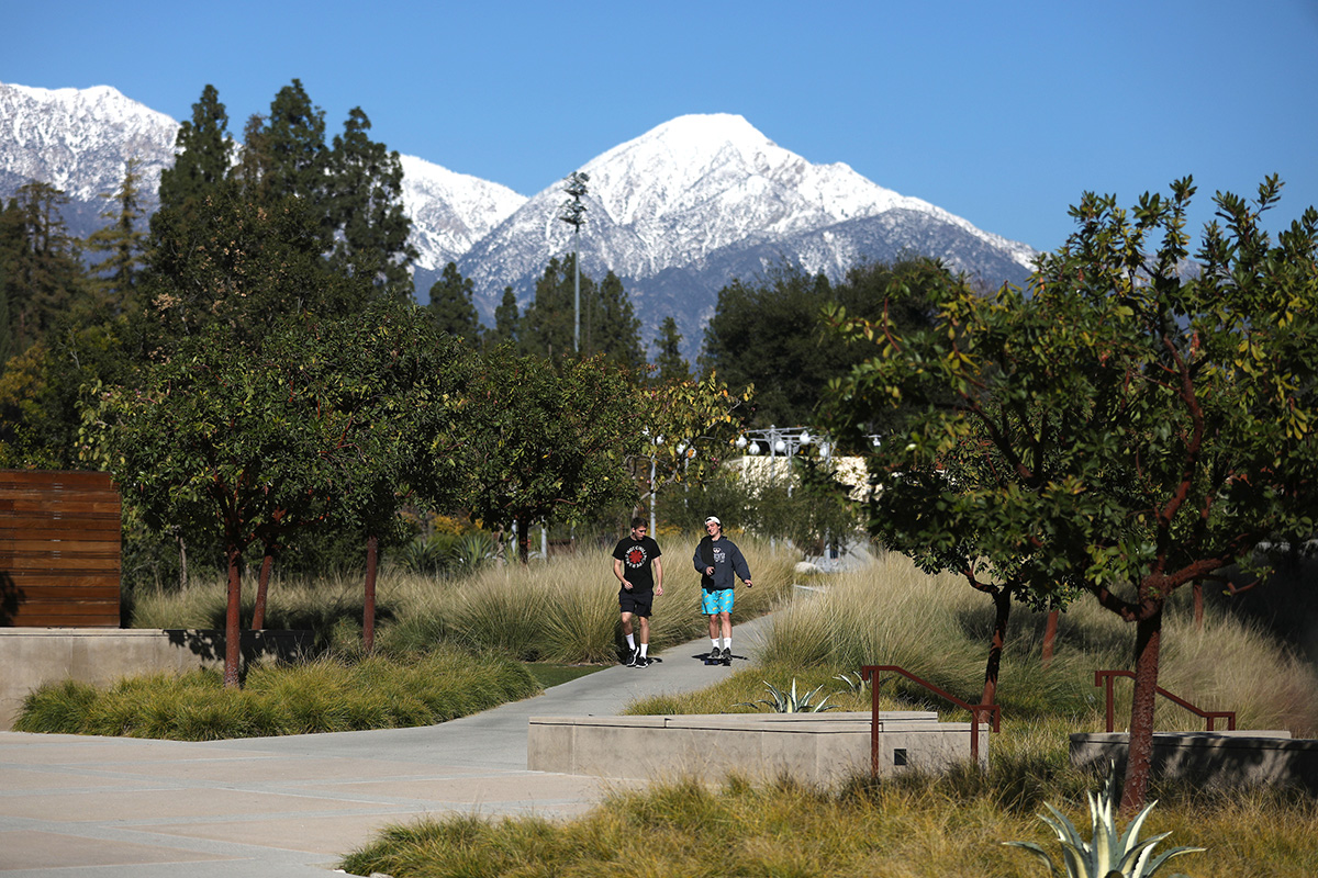 Shot of two students on campus with snowy mountains in the background.