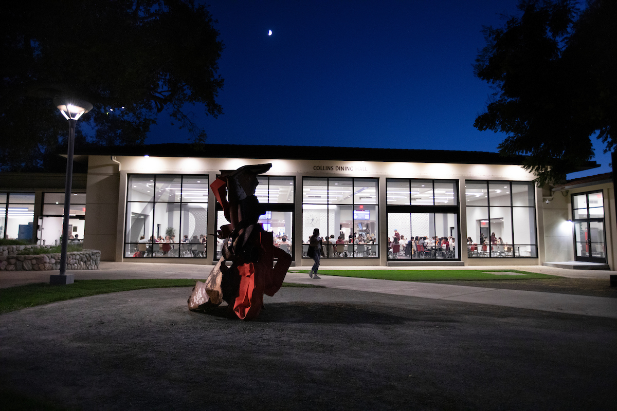 Exterior of Collins Dining Hall at nighttime and Carol Bove's Enigma of Pleasure.