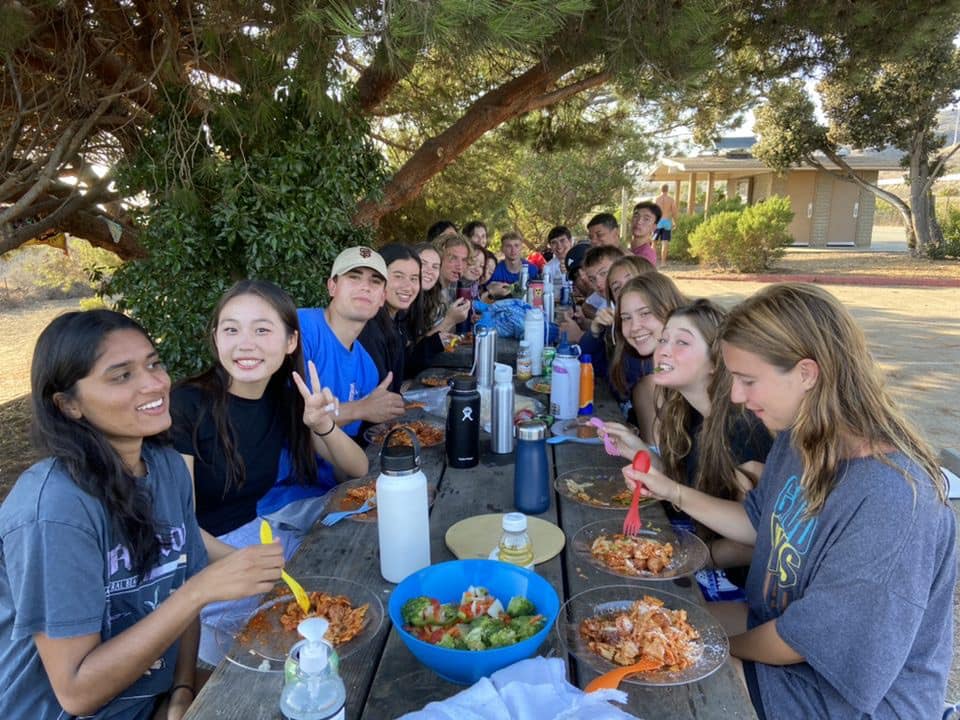 Group of first-year students eating together at a lunch table.