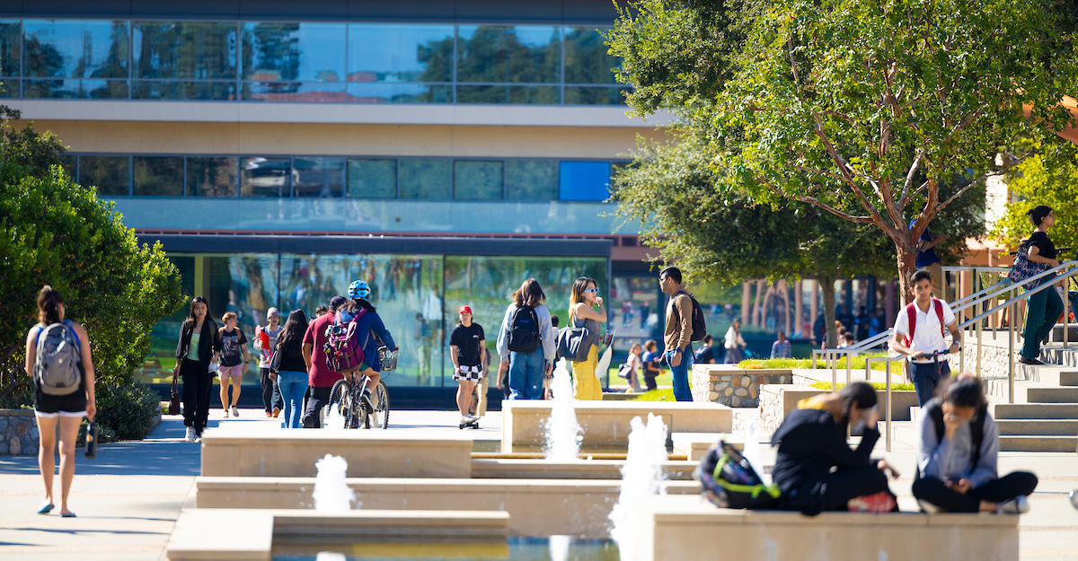 Students walking on campus with Kravis Center in the background.