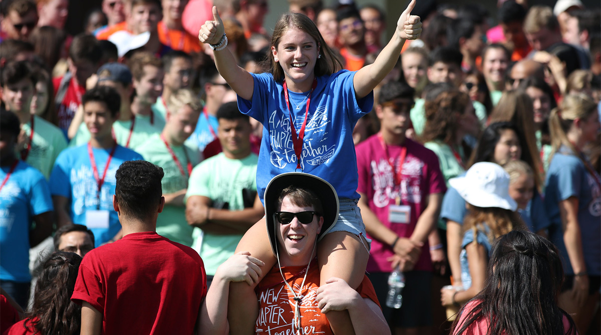 Two students at CMC's Orientation. The female is on the other's shoulders.