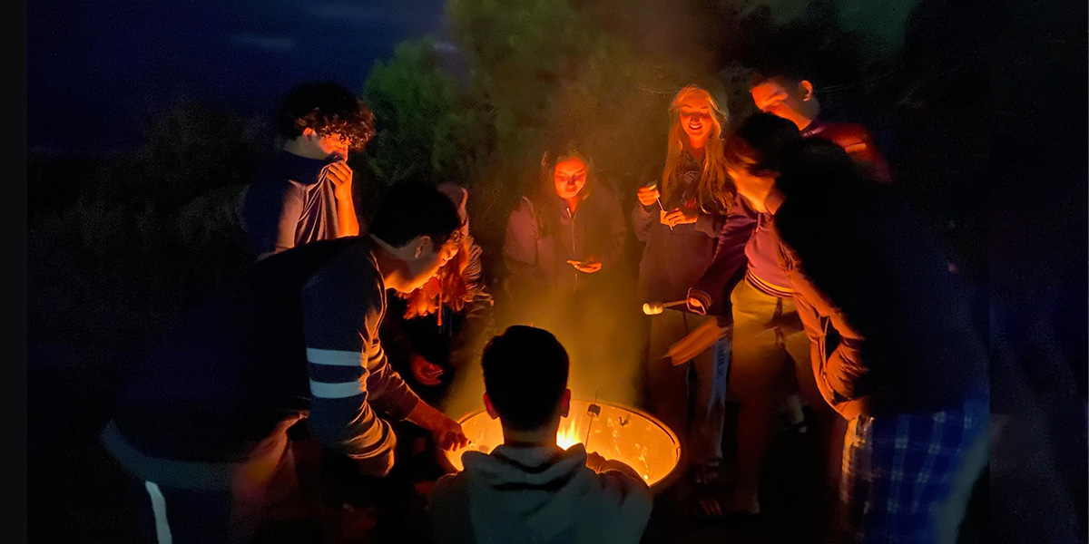 Students gathered around a campfire.