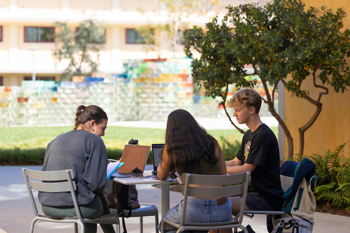 Students studying together at tables in Mid Quad.