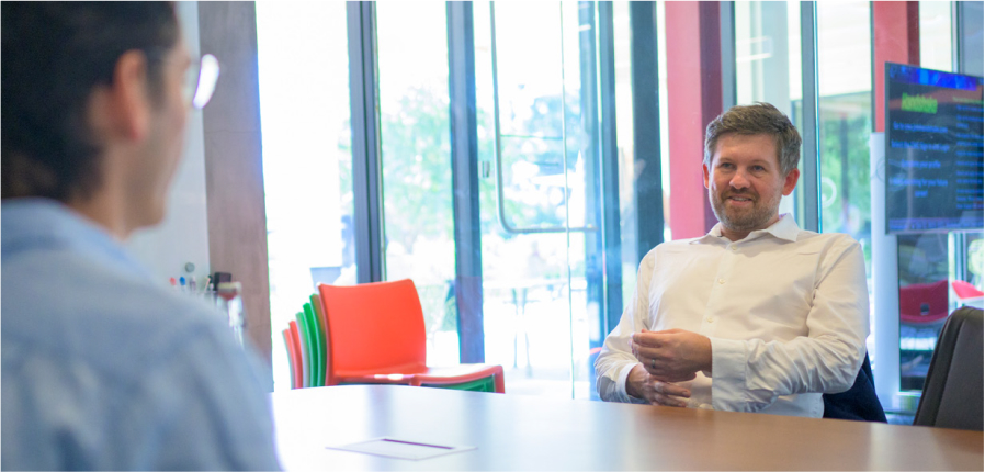 Billy Grayson '00 smiling during a business meeting. 