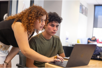 Students working together on laptop.