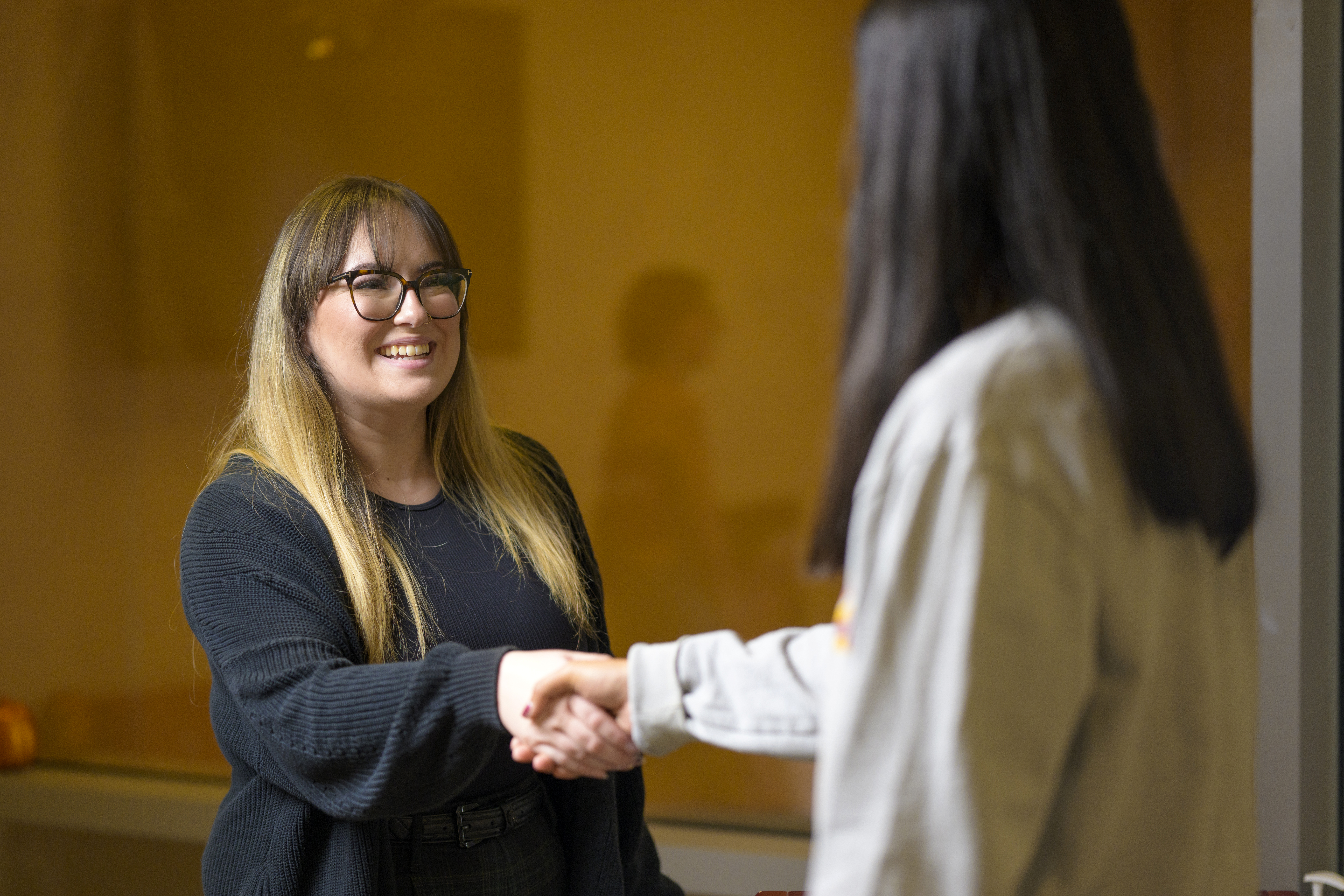 Two students shaking hands. 