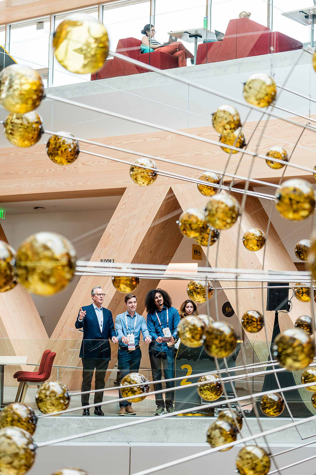 Guests look on at the Atrium, defined by the suspended Magnetic Field installation.