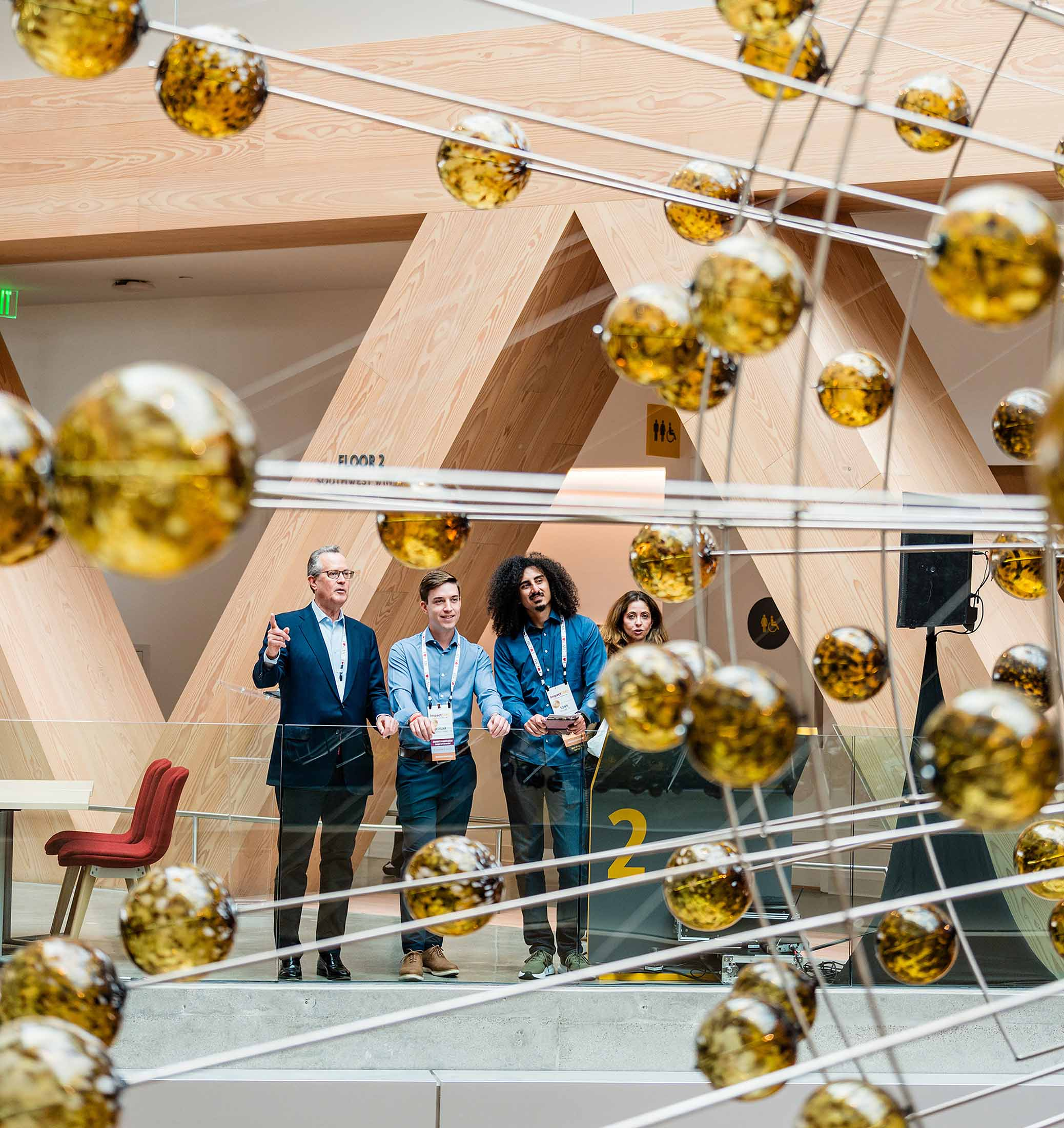Guests look on at the Atrium, defined by the suspended Magnetic Field installation.
