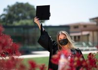 CMC grad in cap and gown at campus photo session