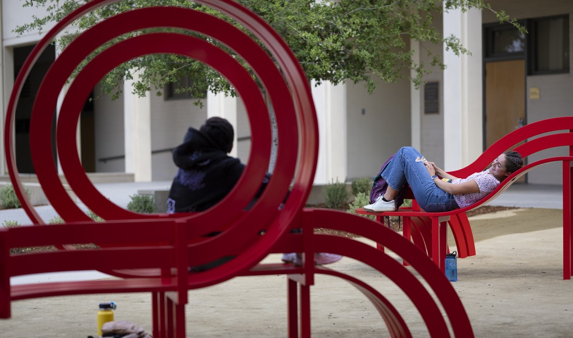 Students sit and lay down with their feet up on the newly revealed benches.