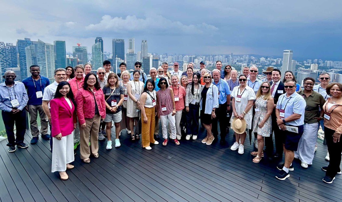 CMC Worldmeet Singapore group on building terrace.
