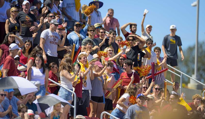 Students and crowd cheering at the football game