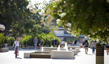 Students on campus among trees and fountains