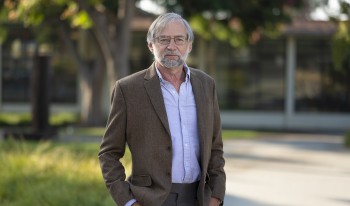 Portrait of a suited Professor Donald McFarlane on campus.
