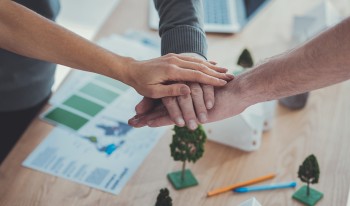 Close up of male and female hands getting together and holding above models