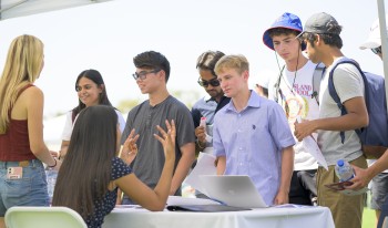 Students find snacks, drinks and shelter from the sun as they move from booth to booth