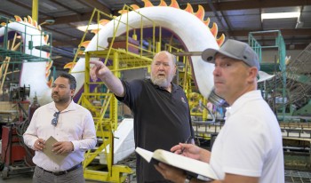 Tim Estes, Fiesta Parade Floats president, center, with Claremont McKenna College representatives at Fiesta Parade Floats in Irwindale.