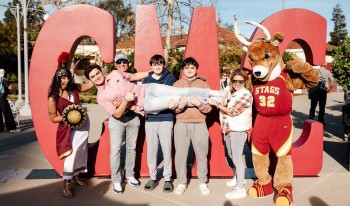 Group of students in front of large CMC signs