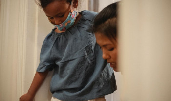 A woman is helping a child put on their shoes.