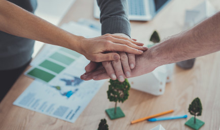 Close up of male and female hands getting together and holding above models