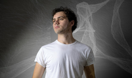 Ian Baine front of a projection of his computational art piece