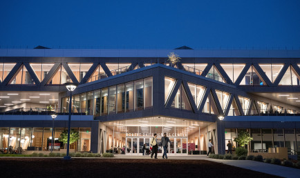 The Robert Day Sciences Center illuminated at night.