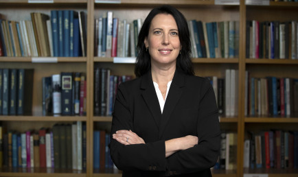Prof. Shanna Rose in front of bookcase