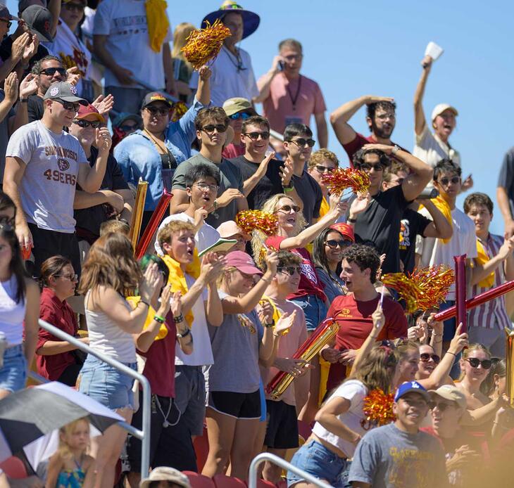 Students and crowd cheering at the football game